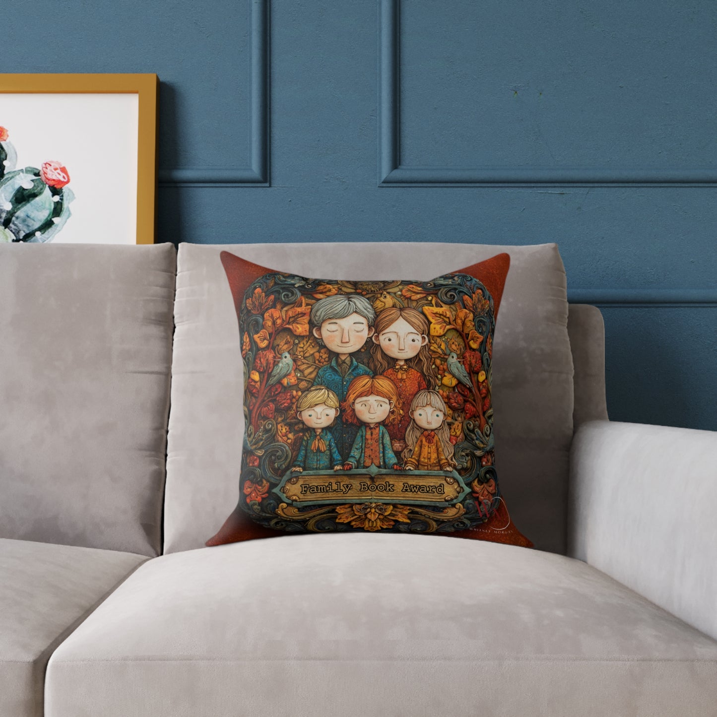 Decorative pillow with a family design on a gray sofa against a blue wall.